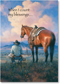 Cowboy next to horse watches cows