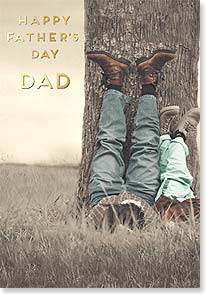 Dad and son laying on ground by tree