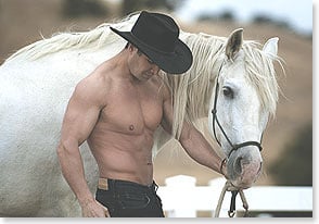 Shirtless cowboy leading horse