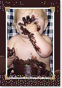 a baby in a high chair smashing chocolate cake all over their face