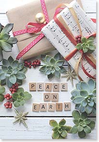 the words peace on earth spelled out on word tiles below wrapped presents