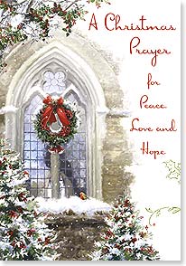 a christmas wreath hangs on an ornate church window 