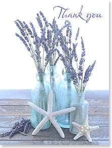 Lavender in blue bottles sitting on boardwalk with starfish