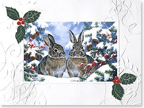 Pair of rabbits sitting amidst snow-covered holly